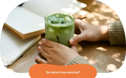 Zielony napój matcha z lodem w szklance, obok otwartej książki. Zastanawiasz się, ile kalorii ma matcha?