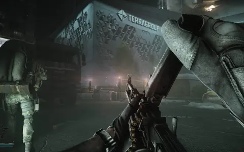 Gracz z karabinem w rękach, gotowy do akcji w grze Escape from Tarkov na PS5. W tle budynek TerraGroup i ciężarówka.