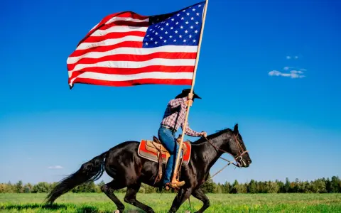 Kowbojka na czarnym koniu niesie flagę USA. To obraz wolności i dzikiego zachodu, pełen ciekawostek o Ameryce.