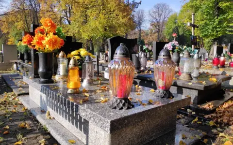 Jesienne zaduszki na cmentarzu. Zastanawiasz się, ile kosztuje miejsce na cmentarzu? Kwiaty i znicze na grobach.