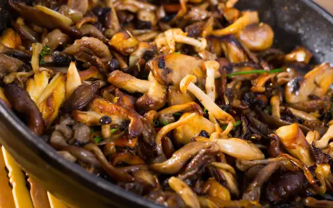 Deliciosas setas al ajillo en sartén, doradas y jugosas, listas para disfrutar.