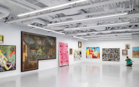 A vibrant art exhibition at Saatchi Yates, featuring diverse paintings and a sculpture, with a striking pink artwork and a figure in a colorful dress.