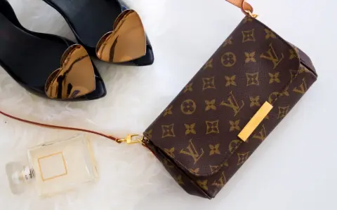 Torebka Louis Vuitton, czarne buty z sercami, perfumy na białym tle.