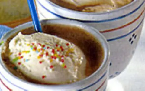 Zwei Becher mit cremigem Vanilleeis, bestreut mit bunten Streuseln. Ein köstliches Eiscafe Rezept für heiße Tage.