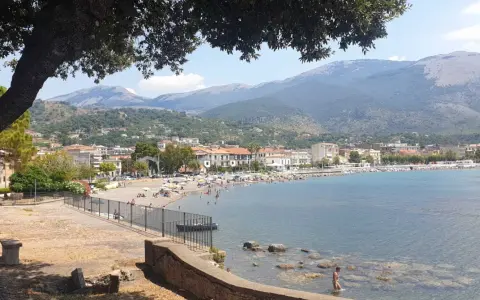 Vista panoramica di Sapri: una spiaggia affollata, il mare azzurro e le montagne sullo sfondo. Ecco cosa vedere a Sapri per una vacanza indimenticabile.