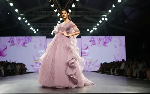 Modelka prezentuje suknię haute couture z muślinu i tiulu na pokazie mody.