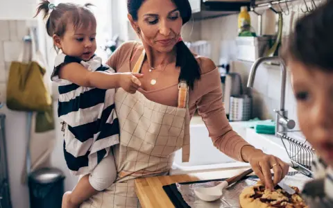 Mutter mit Kleinkind in der Küche, die gemeinsam backen. Tolle Ideen für Rezepte Kleinkinder.
