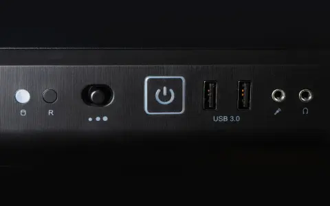 Przycisk zasilania z ikoną symbolizującą skrót klawiszowy uruchom ponownie, obok porty USB 3.0 i gniazda audio.