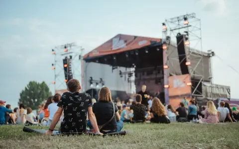 Widownia siedzi na trawie przed sceną podczas Enea Festival Baranowo.
