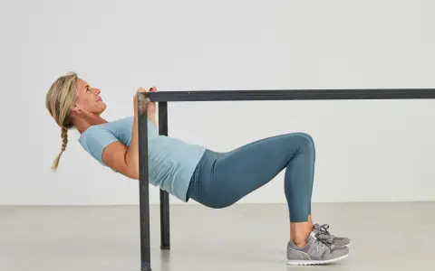 Kvinna utför overhead triceps extension vid en ställning.
