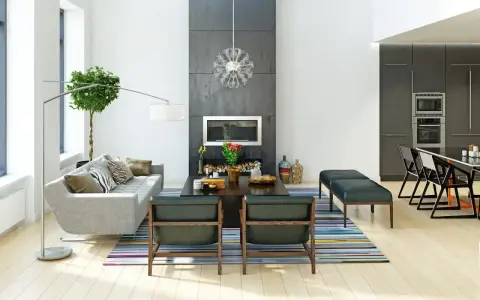 Nowoczesne wnętrza: szara sofa, kominek, designerskie fotele i kuchnia. Różne style wnętrz w jednym, przestronnym salonie.