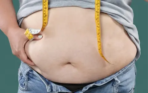 Maßband um den Bauch, um das Ziel, bauchfett reduzieren, zu visualisieren.