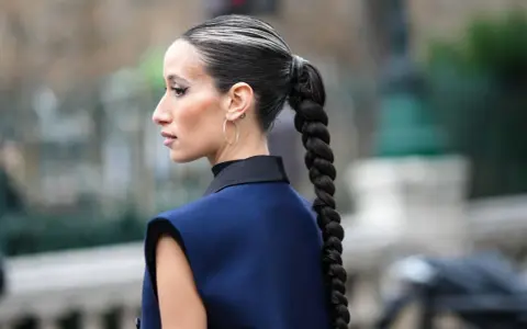 Einfache Frisuren lange Haare: Ein dicker, geflochtener Zopf, der über die Schulter fällt.