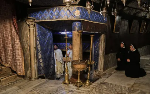 Im Inneren der Geburtsgrotte, wo ist Jesus geboren, stehen Priester und Nonnen in Andacht.