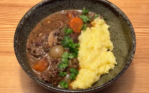 En mustig boeuf bourguignon med möra köttbitar, champinjoner, lök och morötter, serverad med krämigt potatismos.