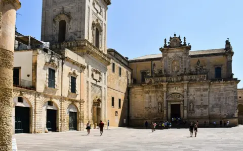 Piazza del Duomo a Lecce, un assaggio di cosa vedere a Lecce in un giorno: la cattedrale barocca e il campanile svettano sotto il sole.