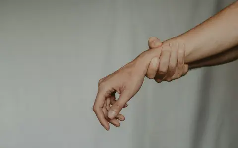 Dłoń trzymająca inną dłoń za nadgarstek. Zaborcza osoba nie chce puścić.