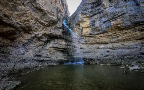 Cascadas en Guadalajara, un estrecho cañón rocoso con una cascada cayendo en una poza de agua clara.