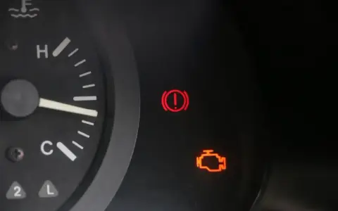 Kontrolka silnika świeci się, wskazując błąd DTC P0010 w Renault. Obok świeci się kontrolka hamulca ręcznego.
