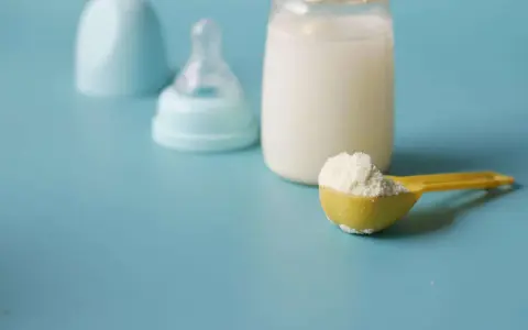 Biberon con latte, tettarella e misurino di latte in polvere, per capire quanto deve mangiare un neonato di 3 mesi.