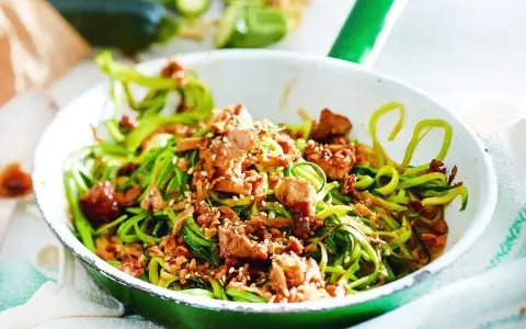 Zucchini-Nudeln mit Tofu und Sesam in einer Pfanne, ein leckeres low carb vegetarisch Gericht.