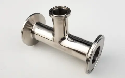 Un raccord clamp en acier inoxydable, en forme de T, prêt à être assemblé pour un système de tuyauterie.