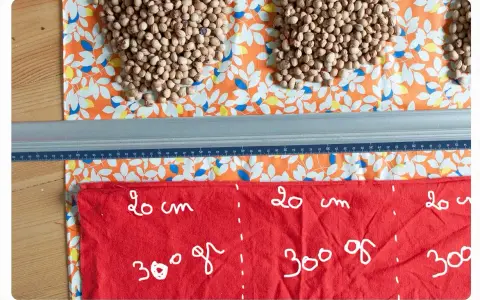 Préparation d'une bouillotte aux noyaux de cerise. Quel tissu choisir ? Ici, un coton imprimé et un tissu rouge marqué pour la découpe.