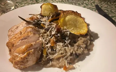 En krämig svamprisotto med skivad kycklingfilé och krispiga potatisskal. Ett perfekt risotto recept för en mysig middag.
