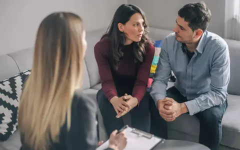 Un couple discute avec un psychiatre lors d'une séance de thérapie de couple.