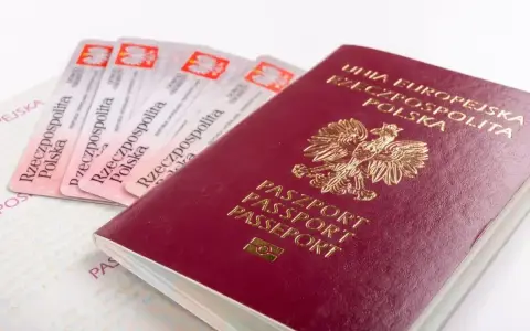 Czerwony paszport RP i kilka dowodów osobistych na białym tle.