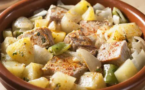 Un delicioso marmitako de atún con patatas, pimientos y cebolla en una cazuela de barro.