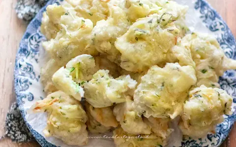 Frittelle di zucchine dolci, dorate e croccanti, servite su un piatto decorato. Un'esplosione di sapore!