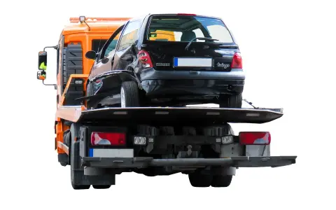 Pomarańczowy holownik zabiera uszkodzonego czarnego Renault Twingo po wypadku na autostradzie.