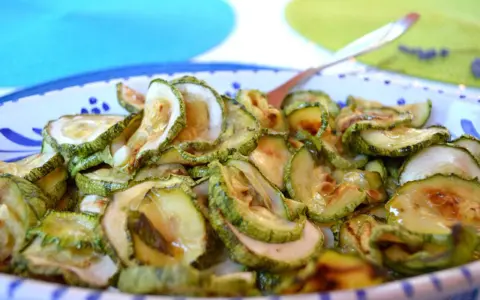Zucchine in carpione, affettate e condite, pronte per essere gustate.