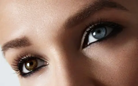 Oczy z heterochromią centralną: jedno niebieskie, drugie brązowe. Makijaż podkreśla ich niezwykły urok.