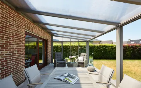 Une pergola moderne avec toit transparent, parfaite pour installer un salon extérieur confortable.