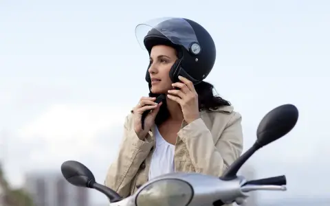 Donna con casco da moto nero, pronta a partire. Non è un luogo dove si buttano i caschi da moto, ma un simbolo di sicurezza.