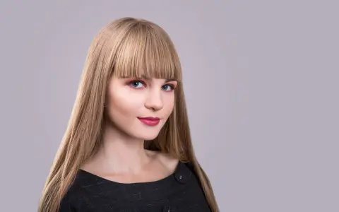 Blondynka z prostą grzywką, która podkreśla jej niebieskie oczy. Różne rodzaje grzywek mogą całkowicie odmienić wygląd.