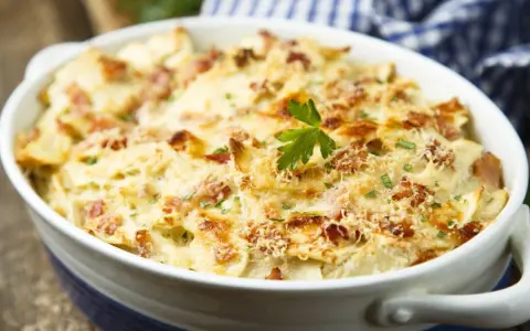 Un plat de tartiflette gratiné, doré et fumant, garni de lardons et de persil. Idéal pour savoir quel vin avec tartiflette.
