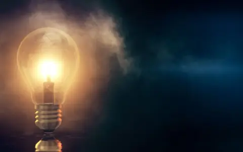 En glödande glödlampa lyser upp mörkret, en symbol för nya idéer och framtiden. Tänk att installera solceller för att fånga solens energi.