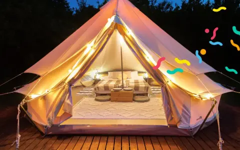 Tenda accogliente illuminata, perfetta per un'esperienza di glamping per famiglie. Letto comodo, tappeti e luci creano un'atmosfera magica.