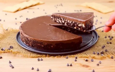 Una fetta di golosa torta fredda senza cottura al cioccolato, con biscotti e nocciole, viene servita.