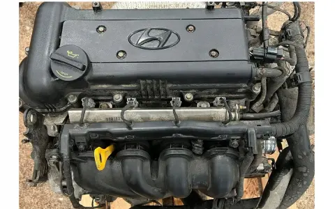 Silnik Hyundai i30 1.4 benzyna, gotowy do montażu. Widoczny korek wlewu oleju i żółta miarka.
