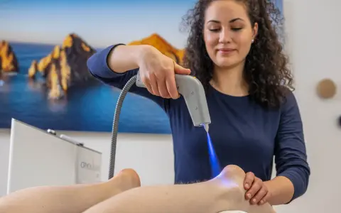 Therapeutin behandelt Fersensporn mit Kälteanwendung. Die Cryo-Therapie lindert Schmerzen, wie bei Liebscher & Bracht empfohlen.