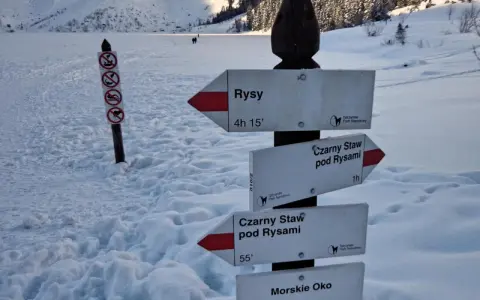 Z Morskiego Oka na Rysy, przez Czarny Staw. Znaki wskazują drogę w zimowych Tatrach.