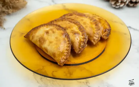 Empanadillas doradas y crujientes, recién hechas en freidora de aire, servidas en plato ámbar.