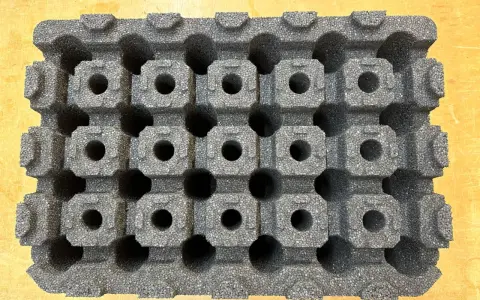 Graues epp kunststoff-Material mit vielen kleinen, quadratischen Hohlräumen, das wie eine Schachtel für empfindliche Gegenstände aussieht.