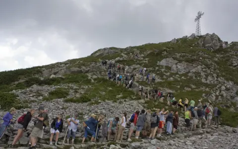 Tłum turystów wspina się na Giewont. Kolejka do wjazdu na szczyt jest długa, a cennik pewnie nie jest tani.