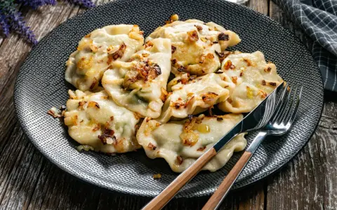Pyszne pierogi z cebulką na talerzu. Zastanawiasz się, ile gotować pierogi, by były idealne?