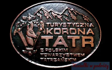 Okrągły medalion z napisem "Turystyczna Korona Tatr" i wizerunkiem kozicy. Symbolizuje zdobywanie szczytów i piękno Tatr.